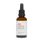 Eine braune Glastropfflasche mit der Aufschrift "medigevity - medi Vitamin D3 & K2 Tropfen" mit einer schwarzen Kappe und einem Tropfer, dargestellt vor einem weißen Hintergrund. Das Etikett zeigt Produktdetails, den Markennamen medigevity und einen deutschen Text.