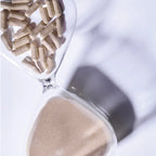 Nahaufnahme einer Sanduhr mit braunen Kapseln im oberen Teil und Sand im unteren Teil, die Zeit und Gesundheit symbolisieren, mit LPG - FAT-BURNING CONCENTRATE von LPG.