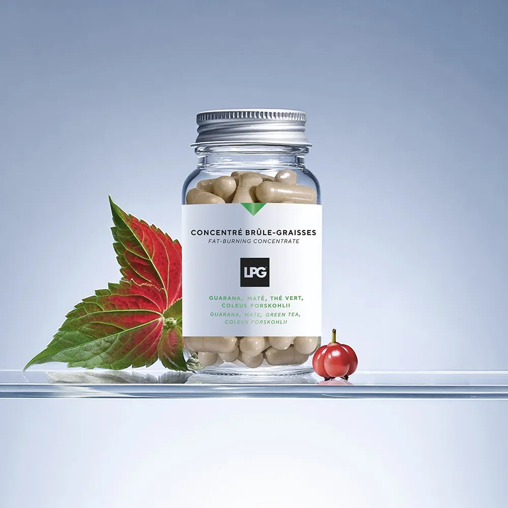 Ein Glas mit beigen LPG - FAT-BURNING CONCENTRATE Kapseln von LPG steht auf einer durchsichtigen Fläche neben einem grün-roten Blatt und einer kleinen roten Frucht vor einem hellblauen Hintergrund mit Farbverlauf.