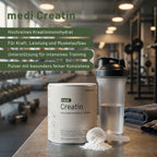 Ein Behälter mit medigevity - medi Creatin Kreatinpulver, eine Shakerflasche mit Wasser und ein Messlöffel Kreatinpulver stehen auf einer Fitnessbank. Im Hintergrund sind Fitnessgeräte und Gewichte zu sehen. Ein Text in deutscher Sprache hebt die Vorteile des Produkts hervor.