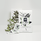 Eine Schachtel LPG - 14 Tage Express Bio Abnehmtee von LPG steht aufrecht auf einer weißen Fläche mit Teebeuteln und grünen Zweigen daneben. Die Verpackung zeigt botanische Illustrationen.